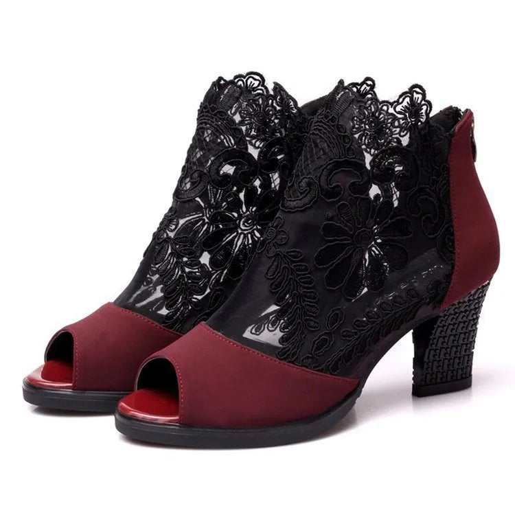 Black lace gladiator sandals with a square high heel and peep toe on a woman's foot