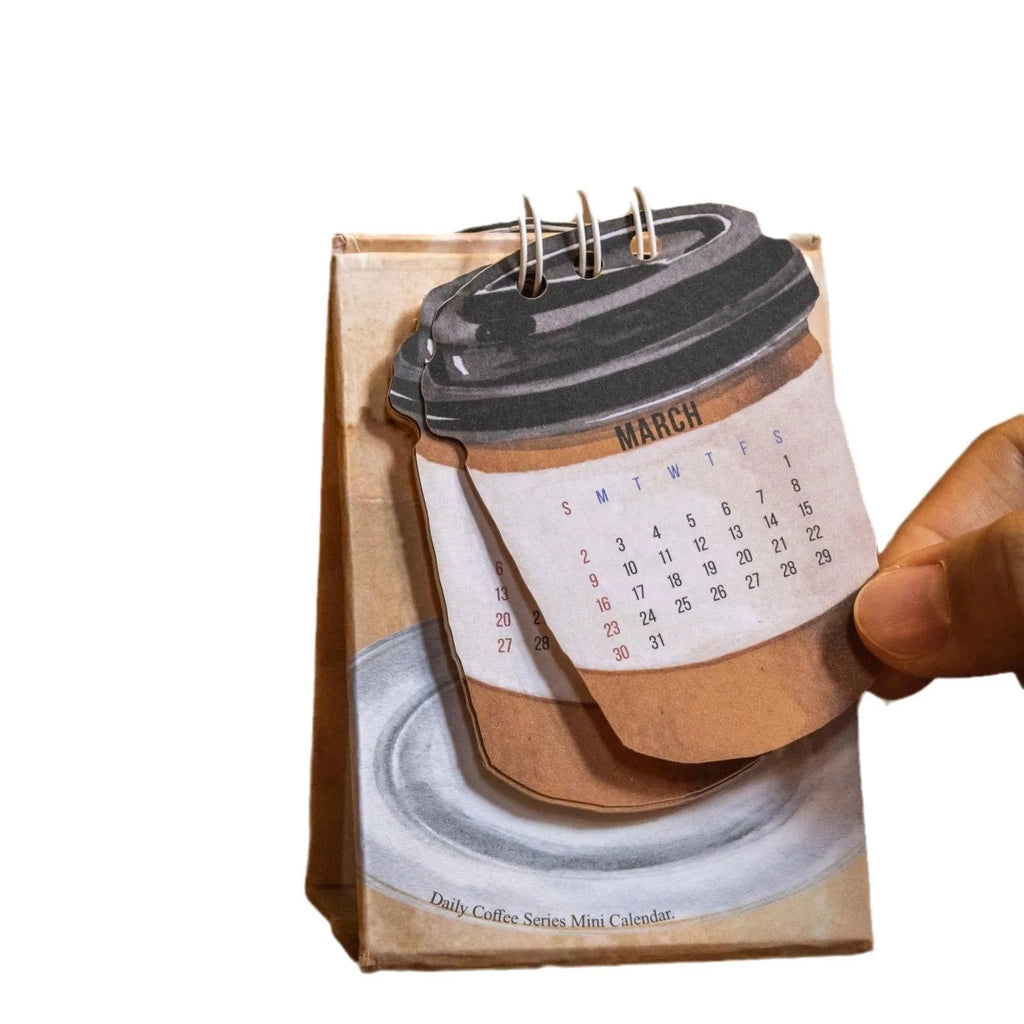 Mini 2025 desk calendar in a simple modern design on a wooden desk