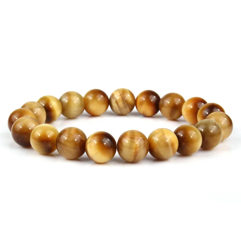 Tiger eye crystal stone bracelet showing round beads available in multiple colours and sizes on a wrist.