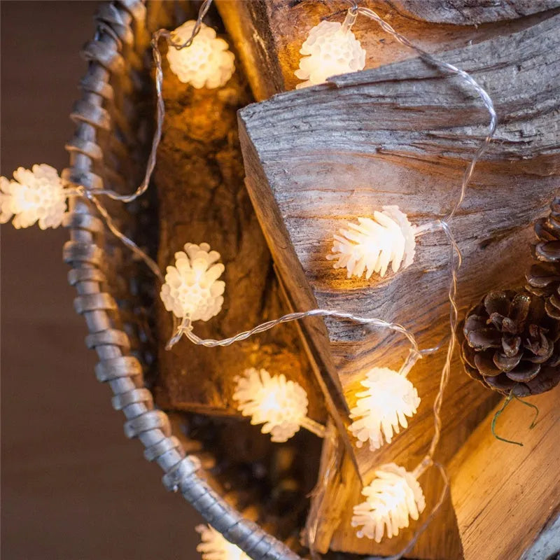 Battery-powered warm white LED pine cone light string with plastic shells, shown in 10 or 20 light options.