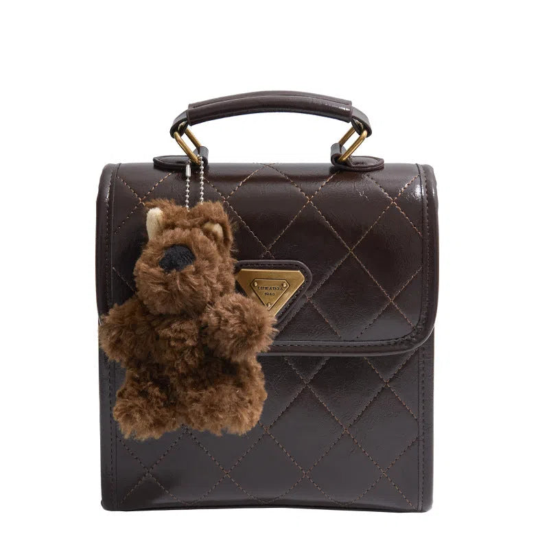 PU mini backpack in brown with stitching detail and pendant, front view