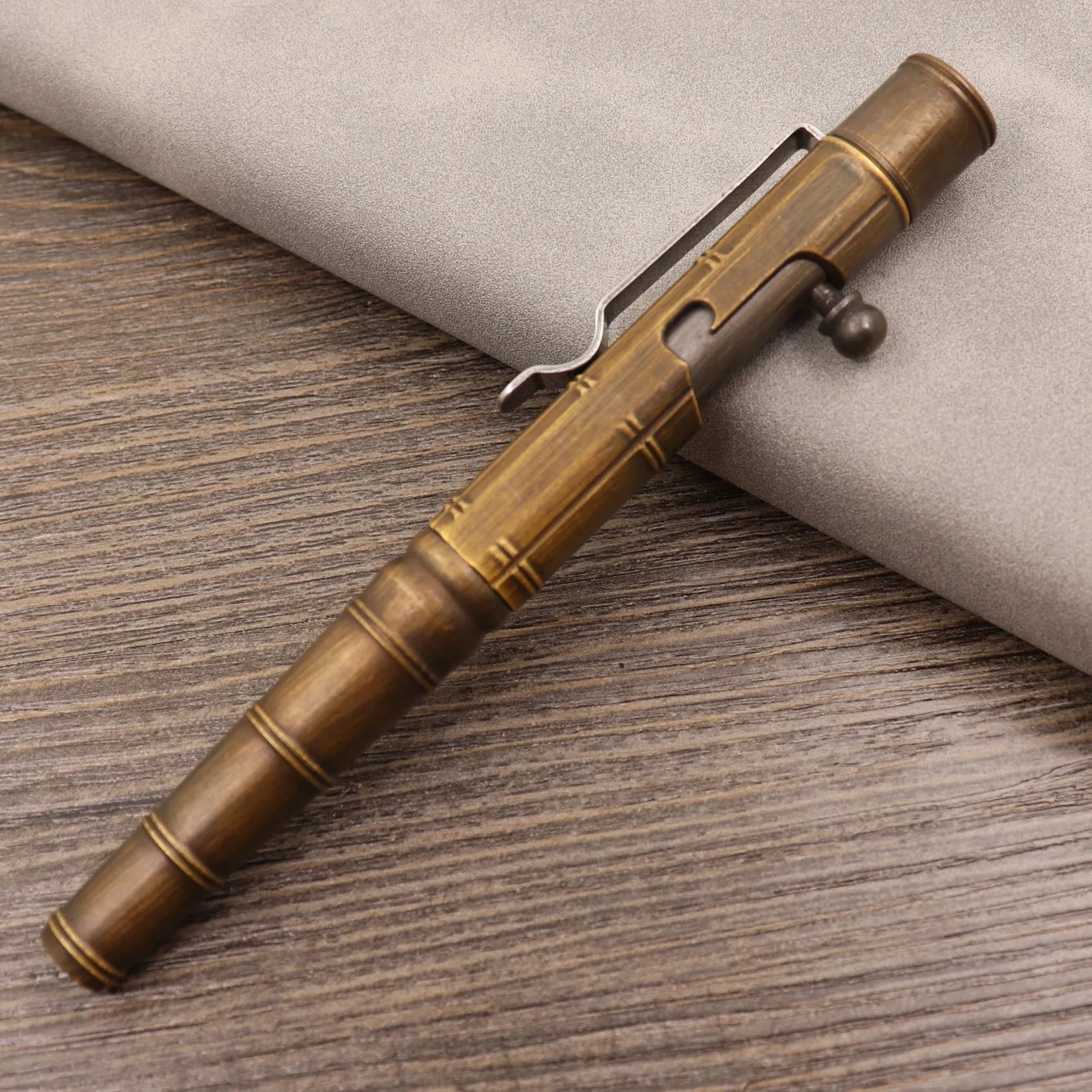 Retro brass tactical pen with press bolt-action mechanism and cylindrical metal barrel
