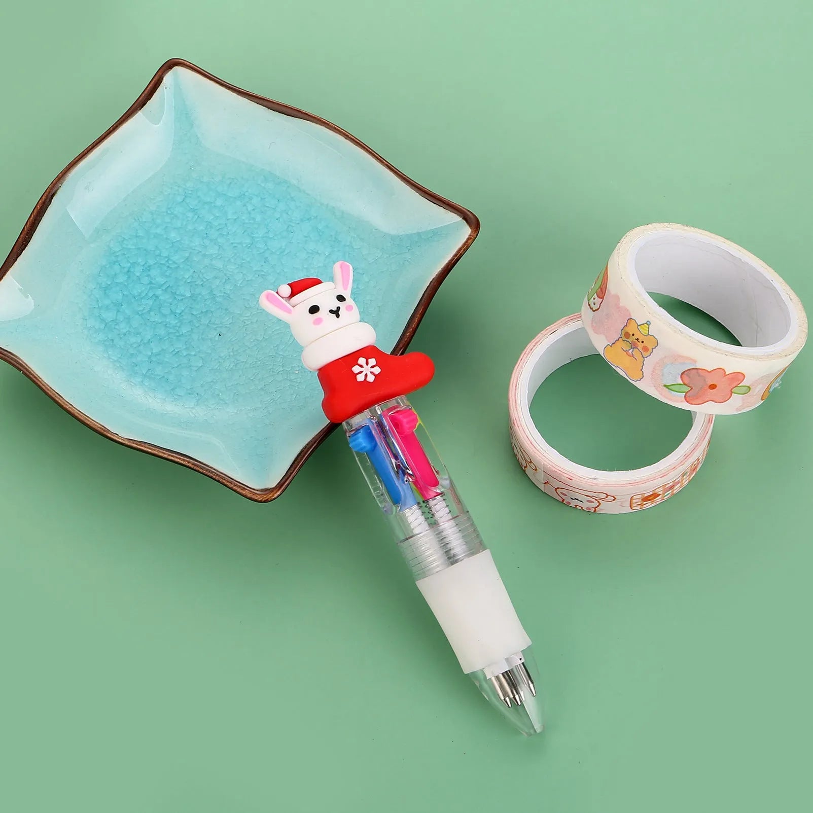 Christmas-themed ballpoint pen with press button, showing designs of snowmen, reindeer, and trees on plastic barrel.