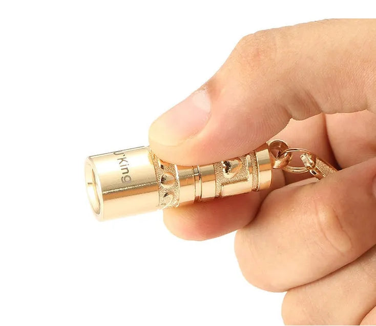 Gold zinc alloy waterproof mini LED flashlight attached to a keychain ring.
