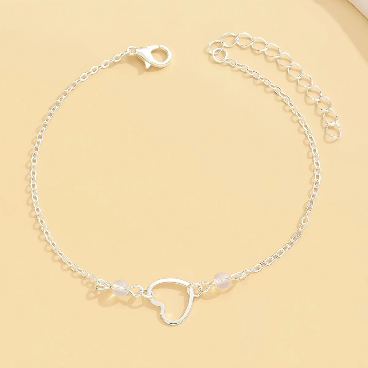 Adjustable women's anklet with heart-shaped pendant in gold or silver alloy metal