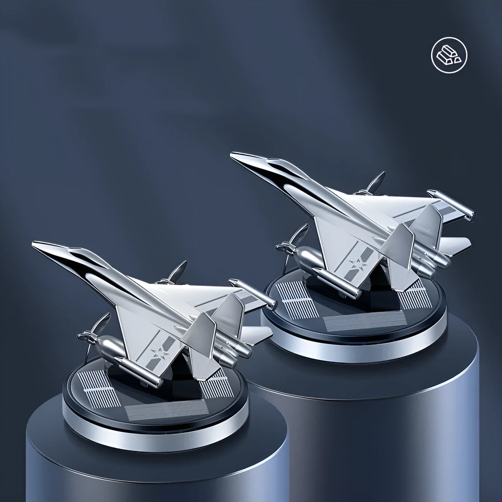 Silver solar powered rotating fighter aircraft perfume ornament on a table.