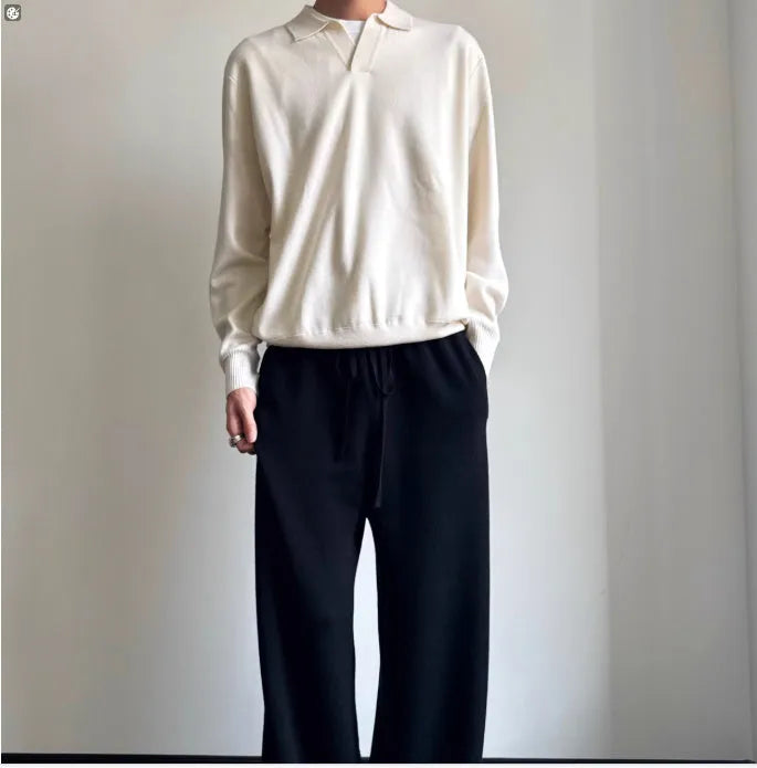 Men's loose-fit lapel-collar wool sweater in navy blue, laid flat showing front design.
