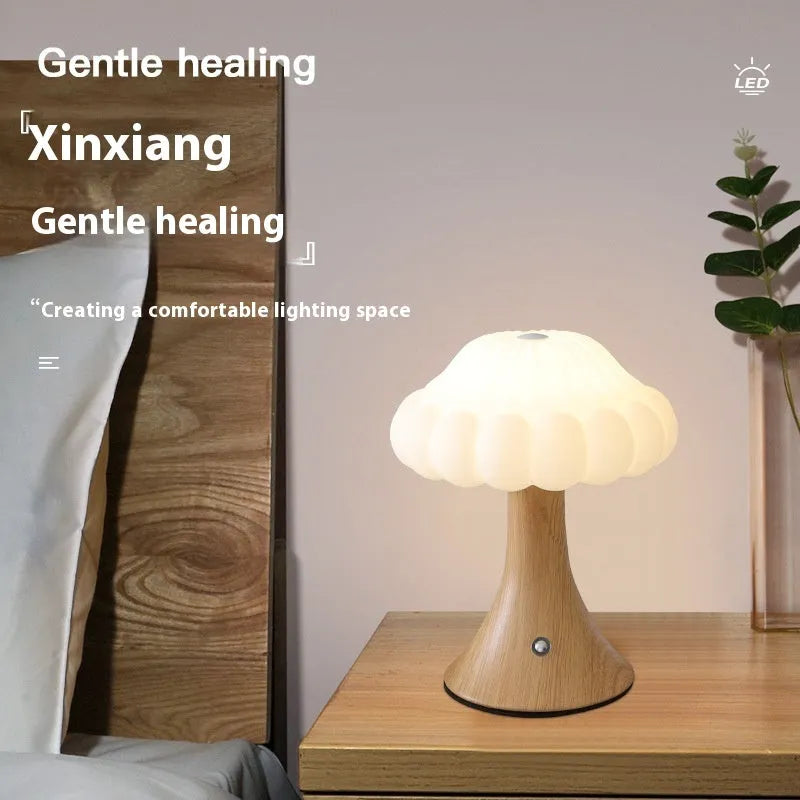 Small mushroom-shaped touch control night light in wood grain finish on a wooden table