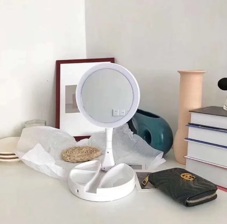 White foldable LED vanity mirror with open storage compartments and USB charging port.