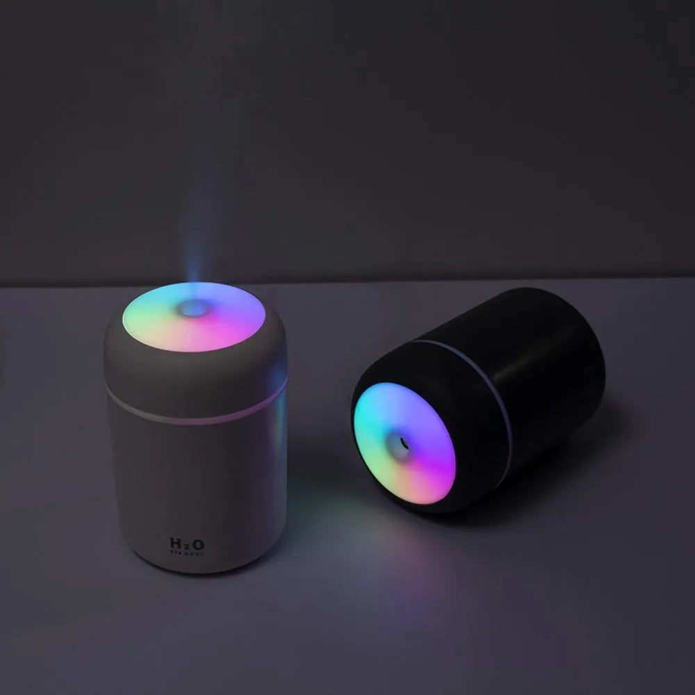 Pink USB mini humidifier with LED lights and water tank on desk