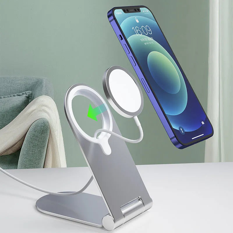 Silver vertical adjustable magnetic phone bracket for iPhone 12 series on a desk.