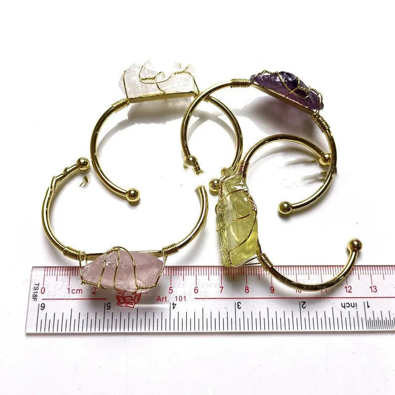 Geometric natural crystal bracelet with gold metal winding on a wrist.