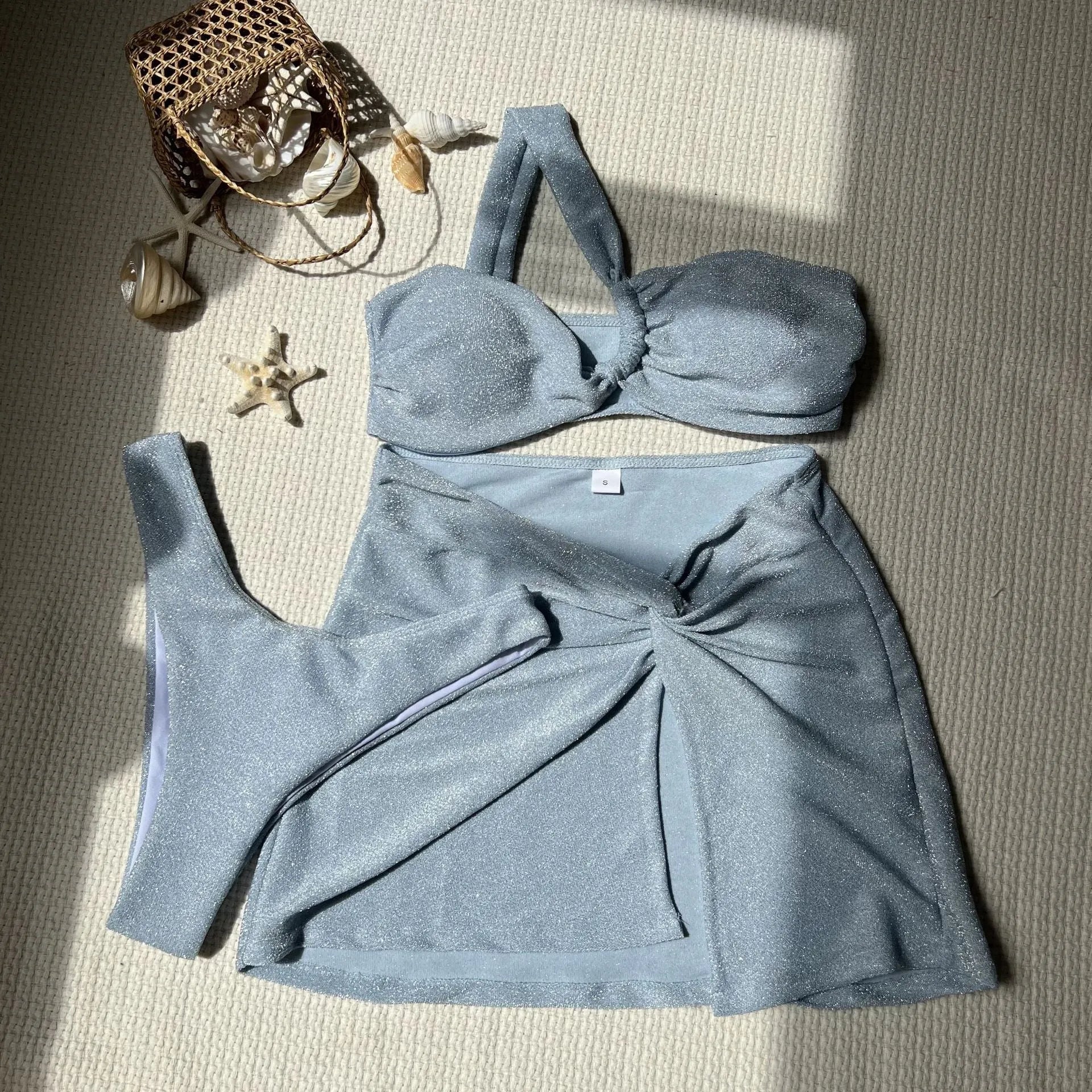 Light green one-shoulder tube top swimsuit three-piece set with matching skirt on a mannequin.
