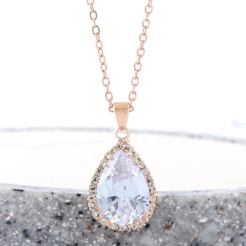 Pink water drop shaped rhinestone necklace with rose gold electroplated alloy pendant on white background