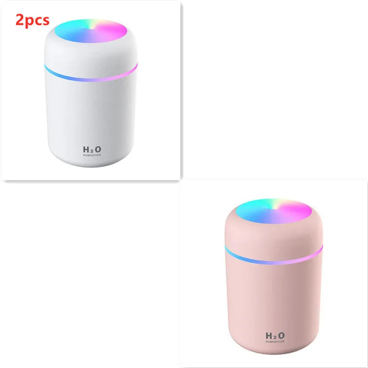 Pink USB mini humidifier with LED lights and water tank on desk