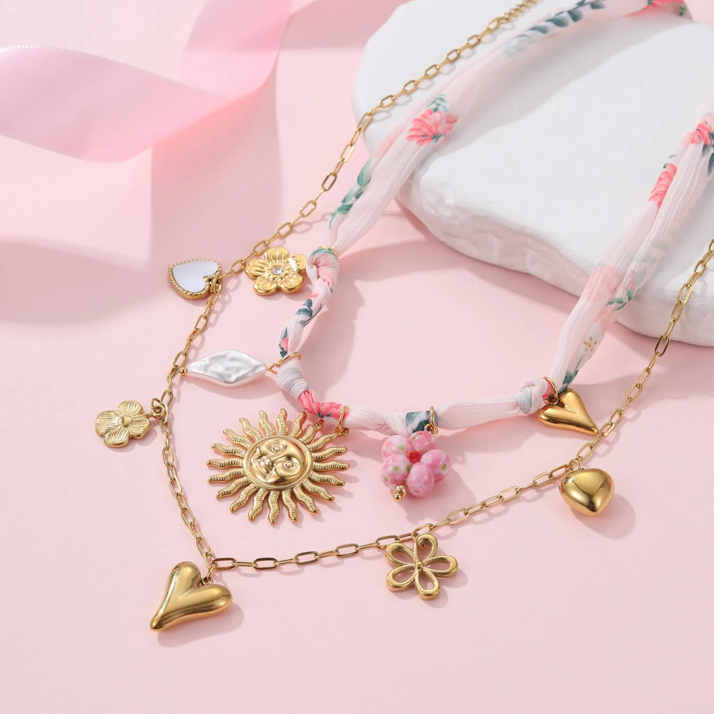 Geometric sun pendant on a stainless steel necklace with an 18K gold electroplated finish.