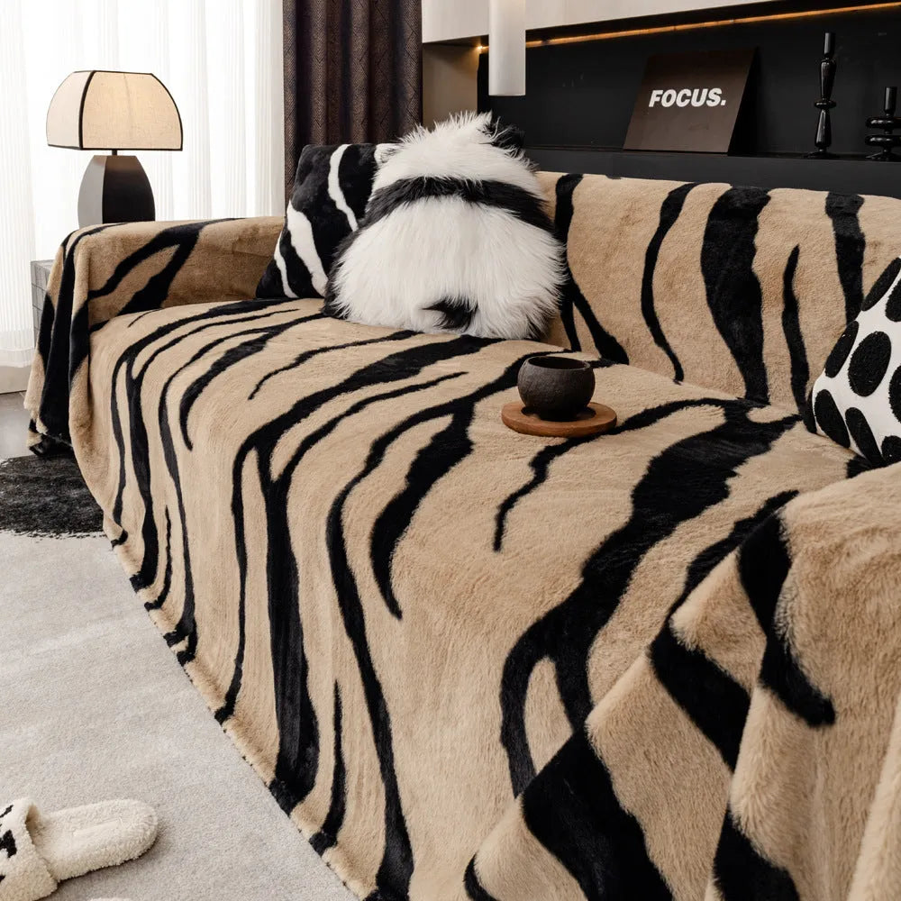 Thickened flannel zebra pattern sofa cover in caramel or black draping over a sofa with non-slip texture visible