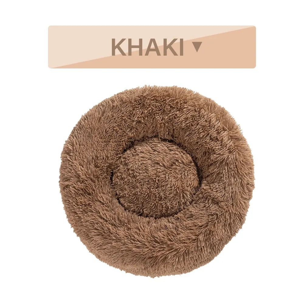 Fluffy donut-shaped pet bed in long plush fabric, shown in a light grey colour.