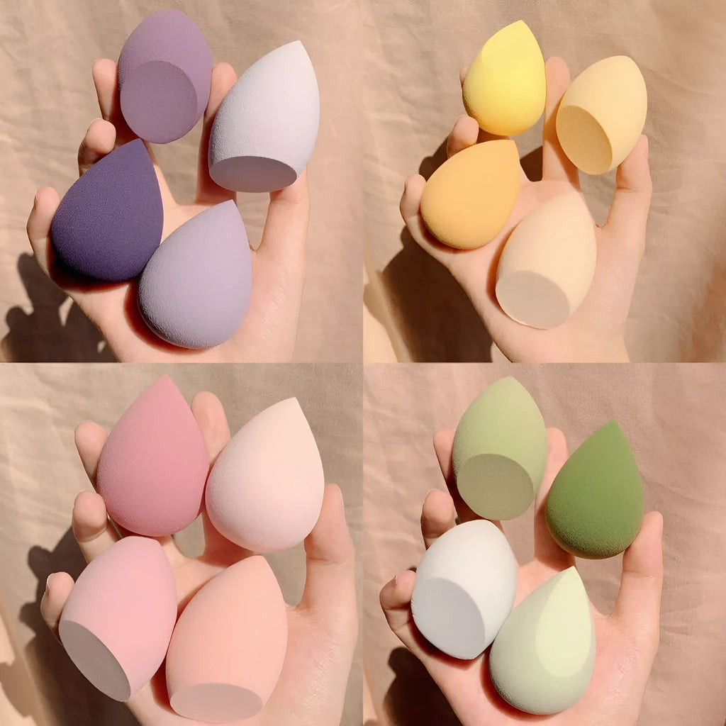 Cube-shaped plastic makeup sponge storage case containing four coloured synthetic beauty egg sponges.