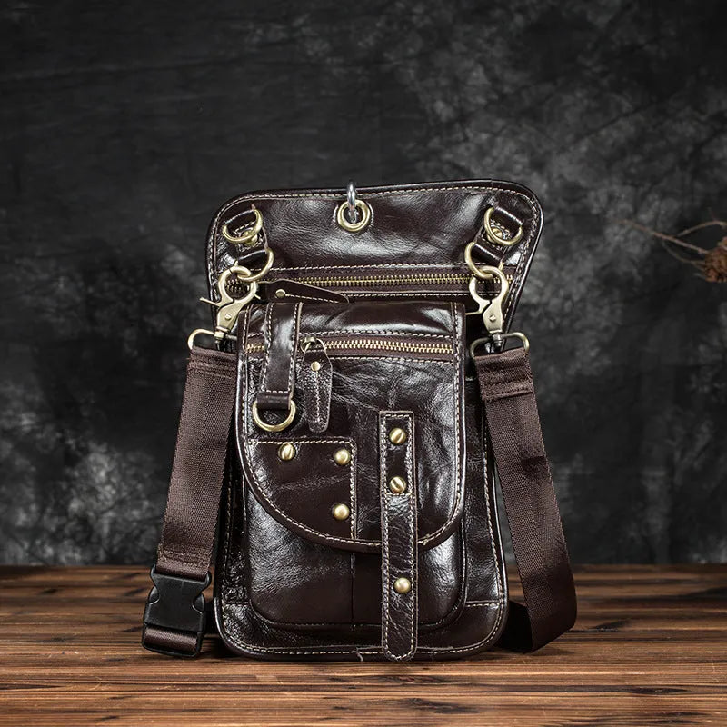 Small black genuine leather men's punk-style fanny pack worn on waist with zipper open