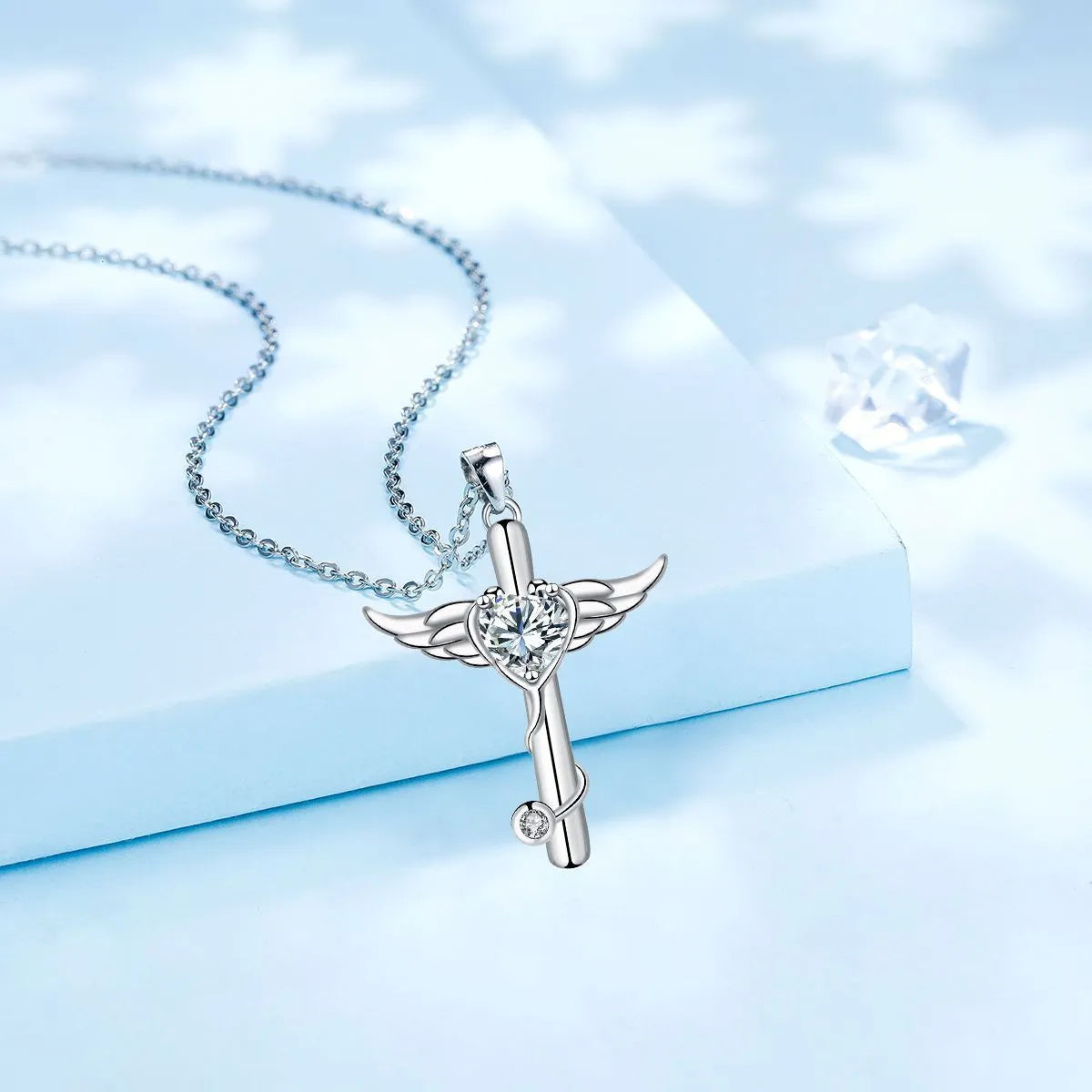 Close-up of a copper wings cross stethoscope pendant necklace on a chain.