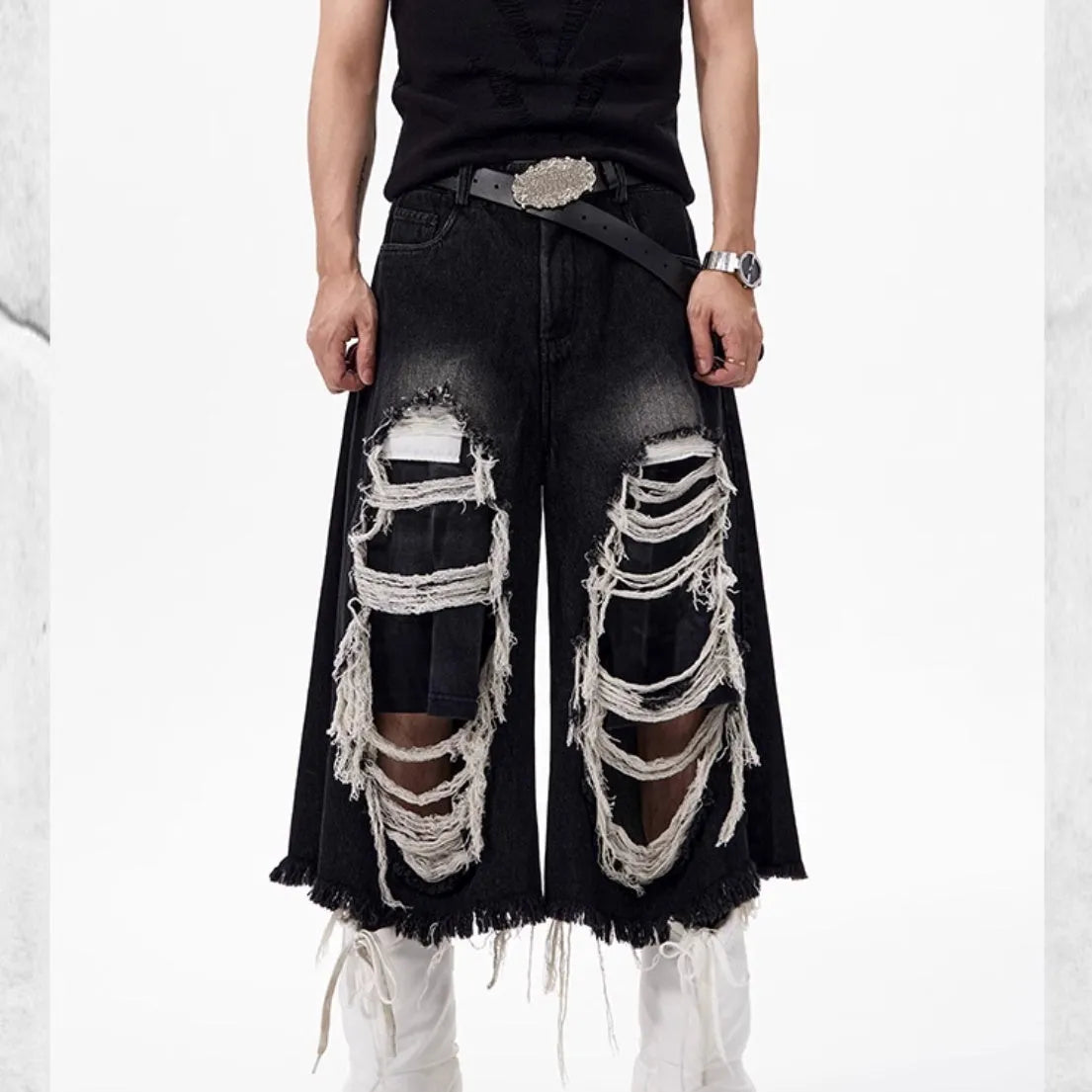 Black wide-leg cropped jeans with ripped patch detail on the legs, showing a mid-high waist and loose fit.