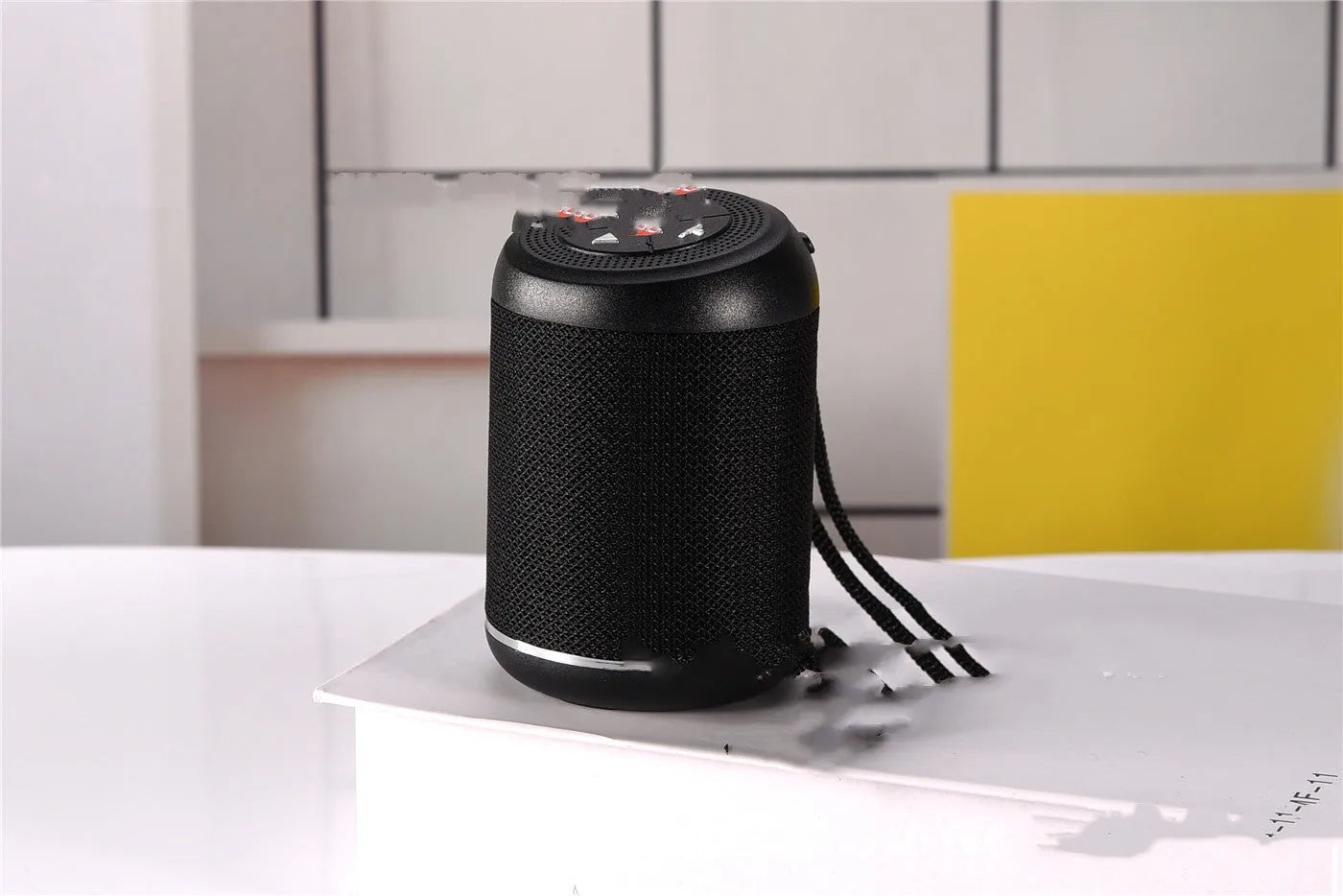 Portable outdoor Bluetooth subwoofer in black with button controls for radio, calls, and playback modes
