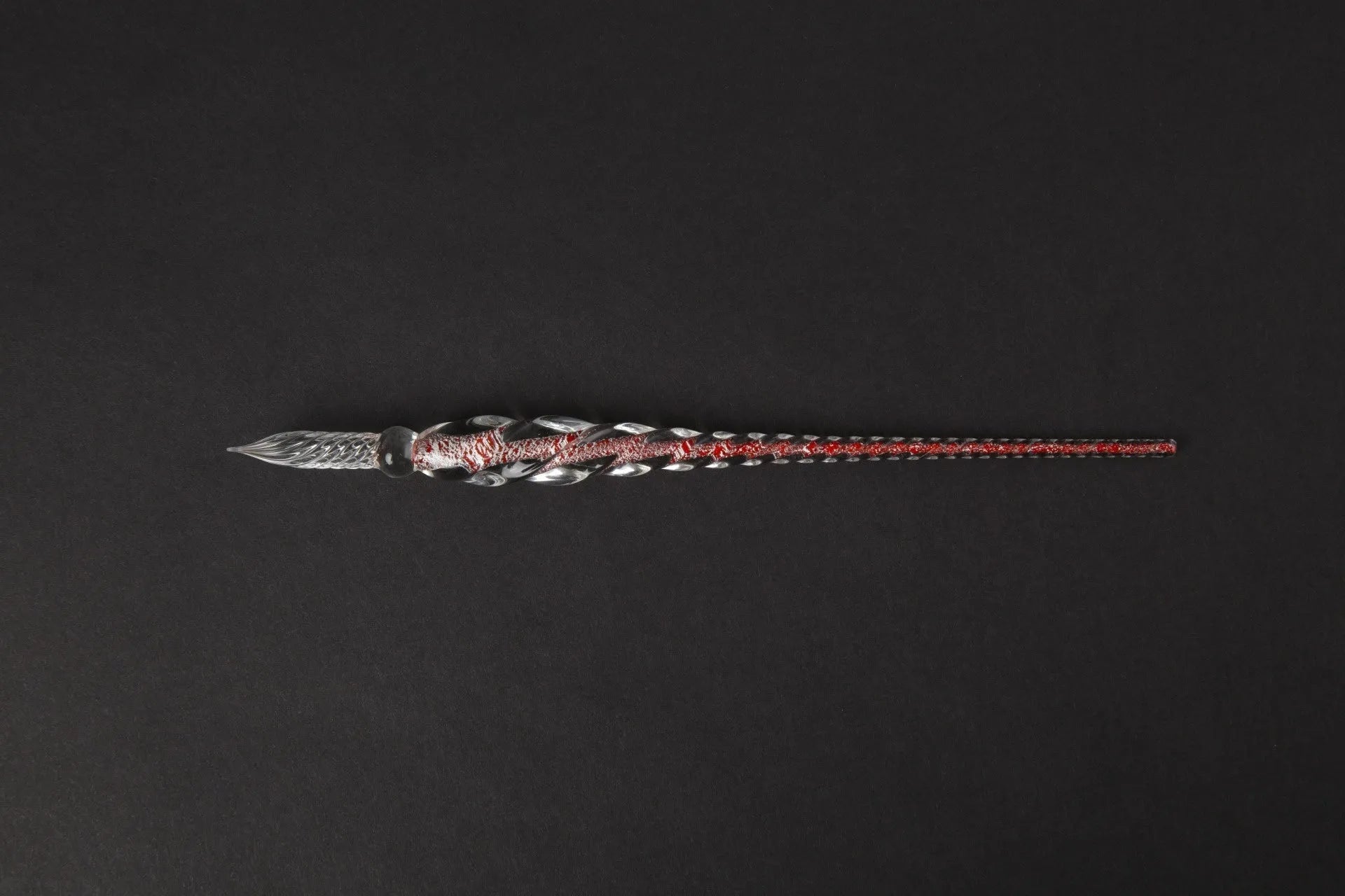 Transparent glass signature pen with coloured ink visible inside, abstract modelling, gift box packaging
