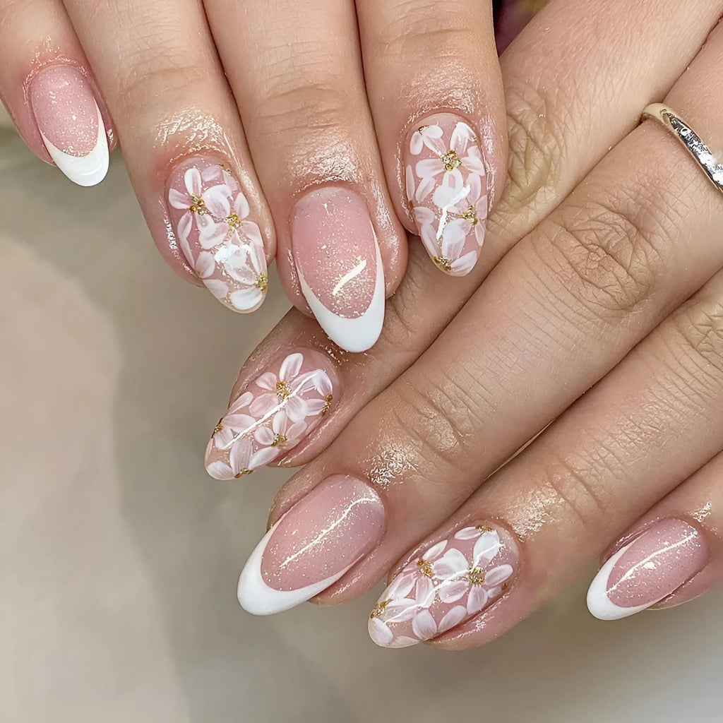 Short almond shaped removable false nails with glossy French tips and glitter flower decoration, colour C625.