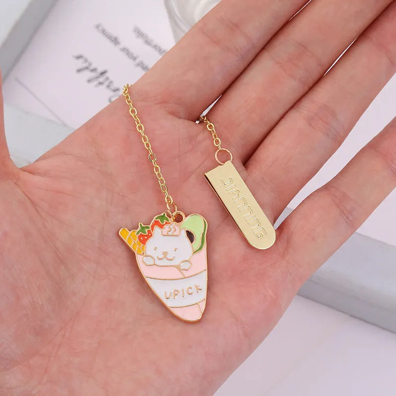 Metal cat pendant bookmark showing one of four cartoon designs: Strawberry Cake, Fruit Roll, Cherry Sleeping, or Yellow Fortune Bag cat.