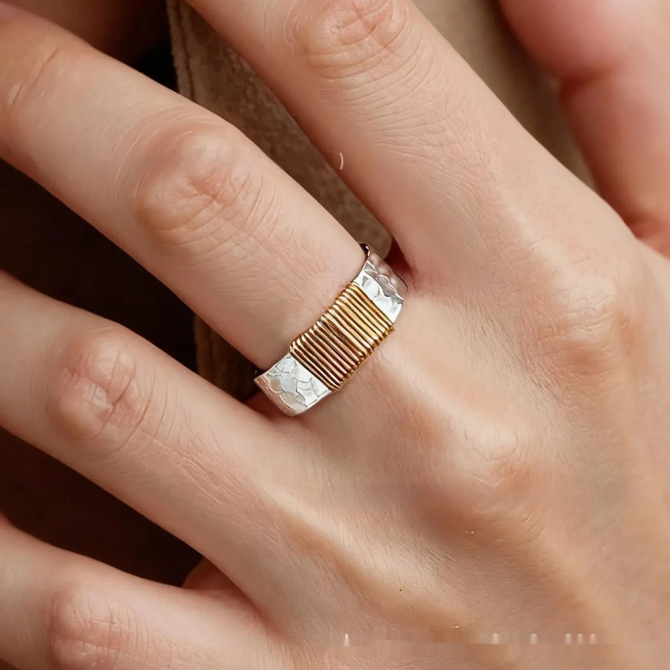 Copper wide face ring with irregular coil design in silver-gold colour.