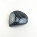 Black gear shift cover with a carbon fibre pattern for car interior styling.