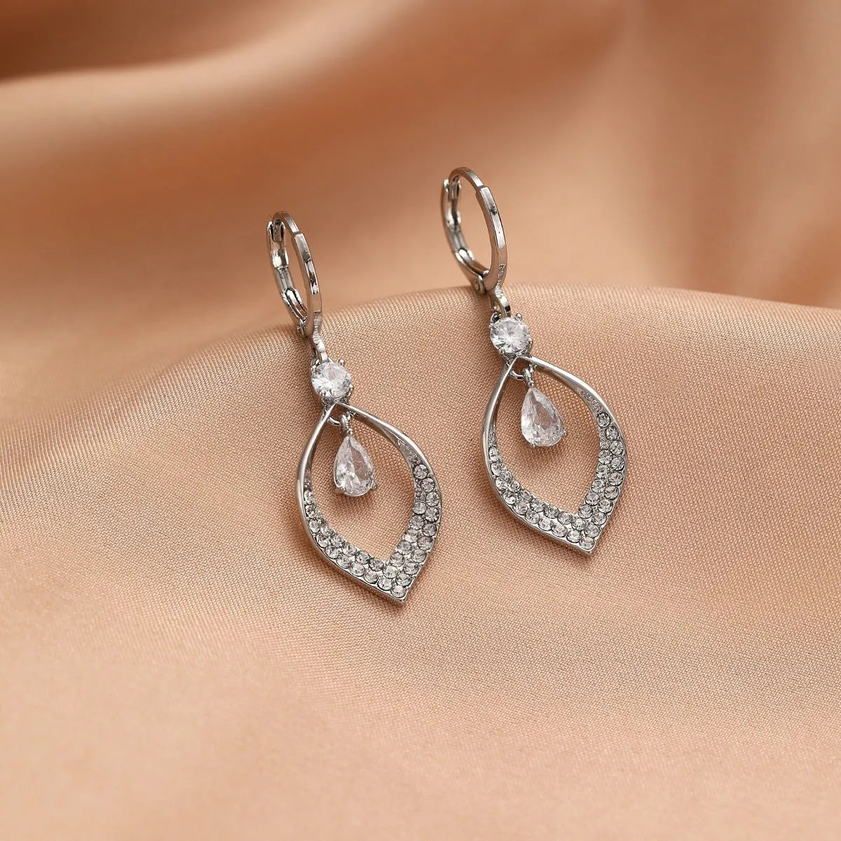 Gold and silver water drop tassel earrings with zircon stones on a copper base.
