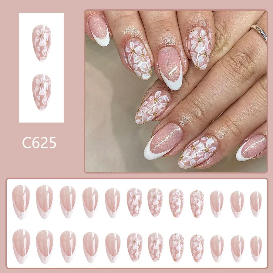 Short almond shaped removable false nails with glossy French tips and glitter flower decoration, colour C625.