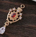 Small hollow water drop-shaped pendant with crown design and micro zircon details in various colours.