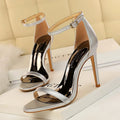 White high-heeled sandal with an open toe and a buckle-fastened ankle strap.