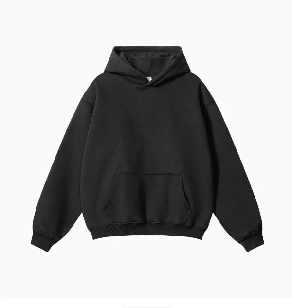 Man wearing a loose-fit cotton terry hooded sweater with drop-shoulder sleeves in a solid colour.