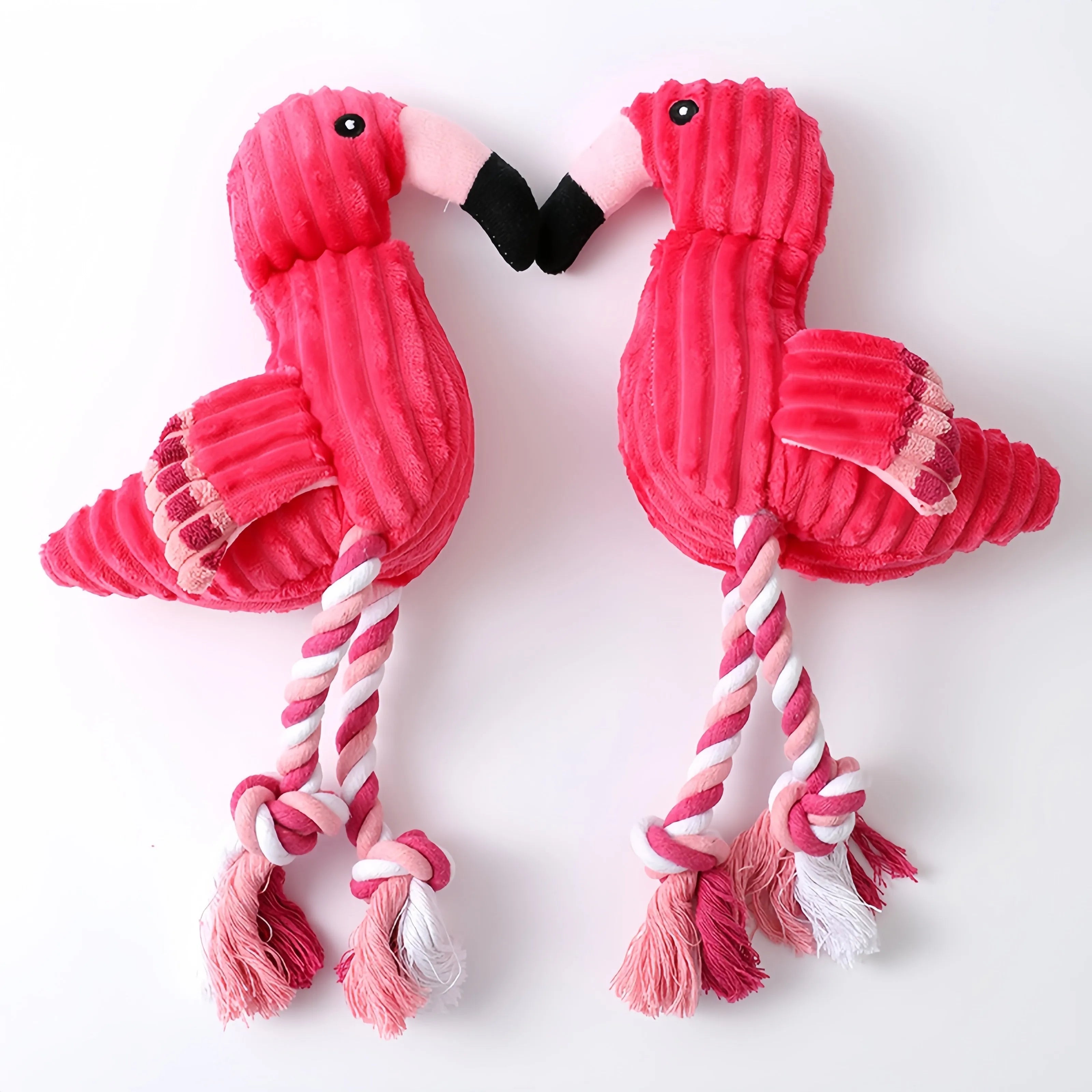 Pink corduroy hippo and parrot squeaky plush dog toys on a white background.