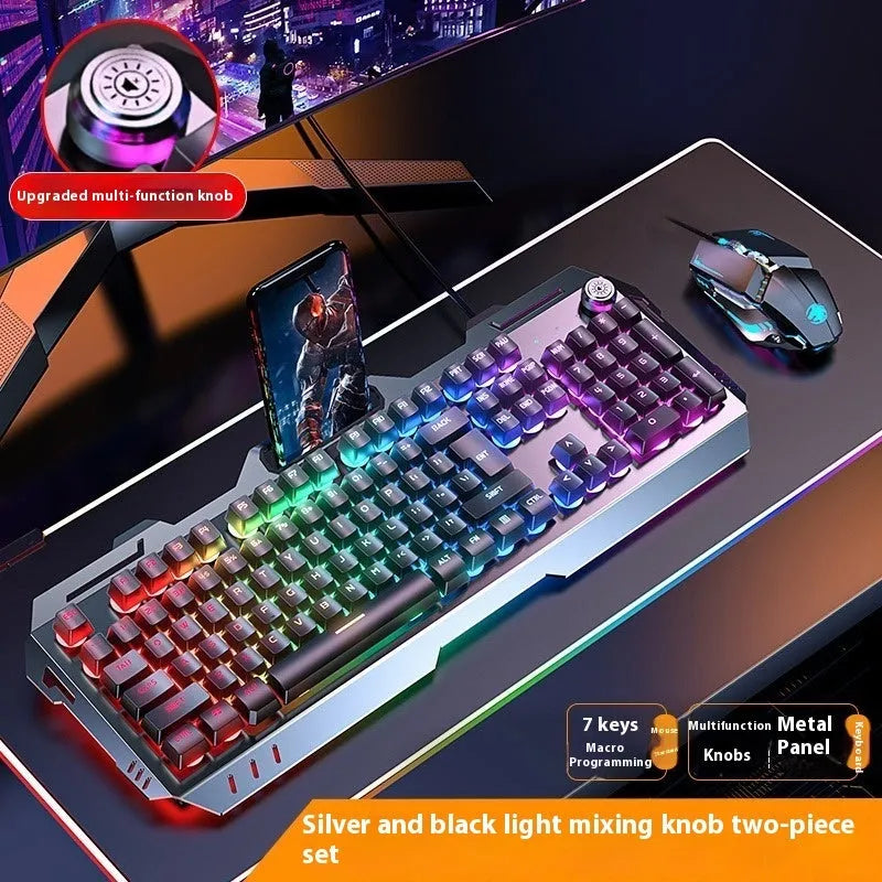 Aluminium gaming keyboard with volume knob, shown in metal grey with RGB lighting alongside optional macro mouse and headset.