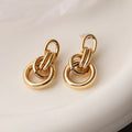 A pair of real gold coloured geometric earrings with an irregular shape, made from copper, style wild.