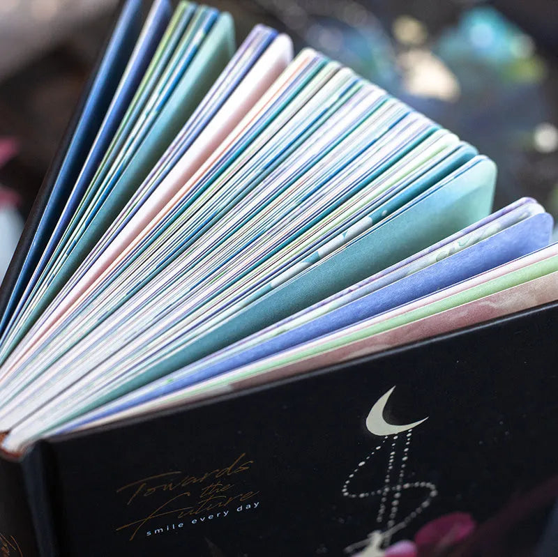 A5 notebook with a luminous cover open to show internal colour illustrations, next to Purple, Light Blue, Gold, and Deep Blue colour options.