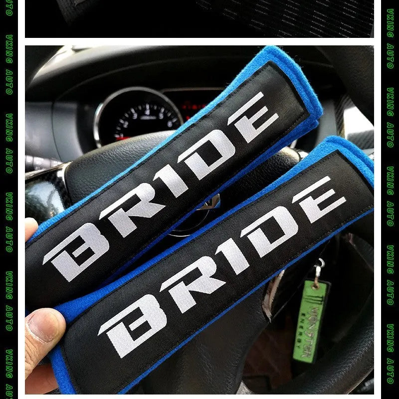 Pair of black car seat belt shoulder pads made from cotton and sponge cloth, showing size and embroidery detail.