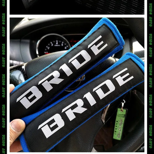Pair of black car seat belt shoulder pads made from cotton and sponge cloth, showing size and embroidery detail.