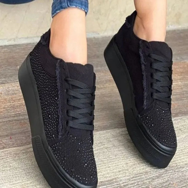Women's black casual flat shoes with thick rubber sole, lace-up front, and rhinestone decoration.