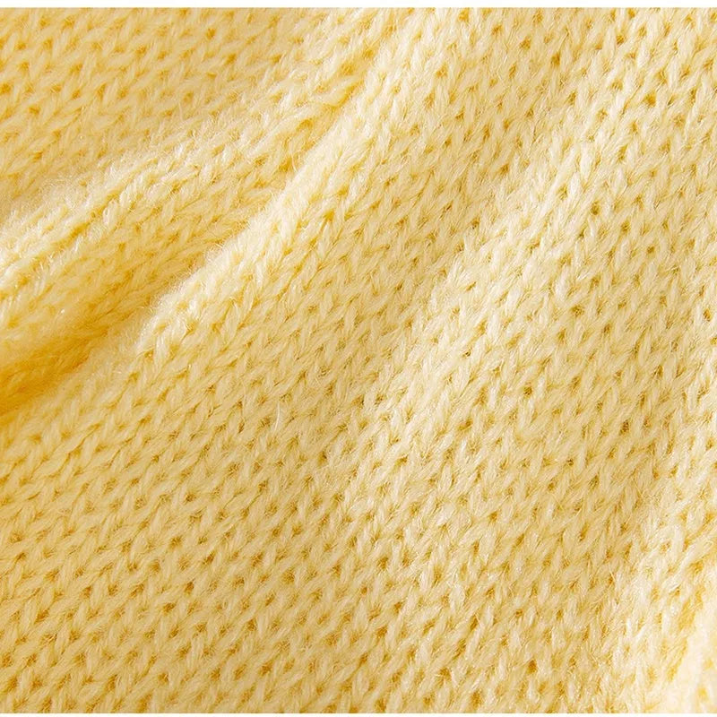 Yellow knitted dog sweater with star pattern and turtleneck on small breed puppy