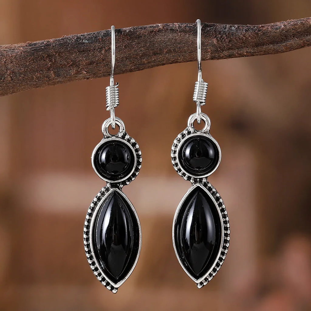 A pair of black and purple vintage geometric pendant earrings with bohemian style on a white background.