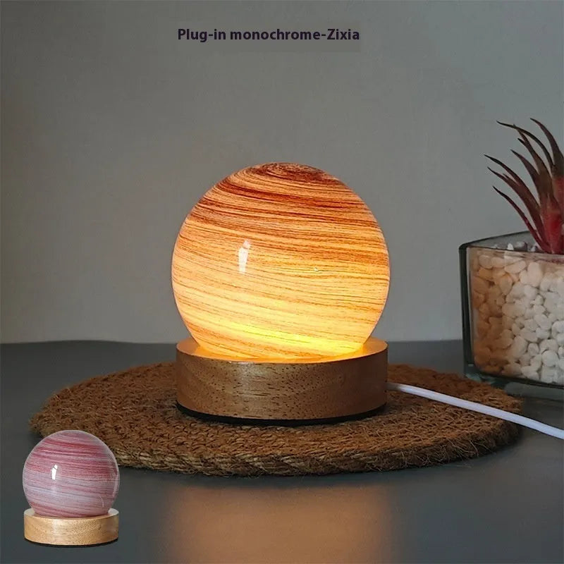 Planets themed USB night light with modern design and three-colour dimming on bedside table.