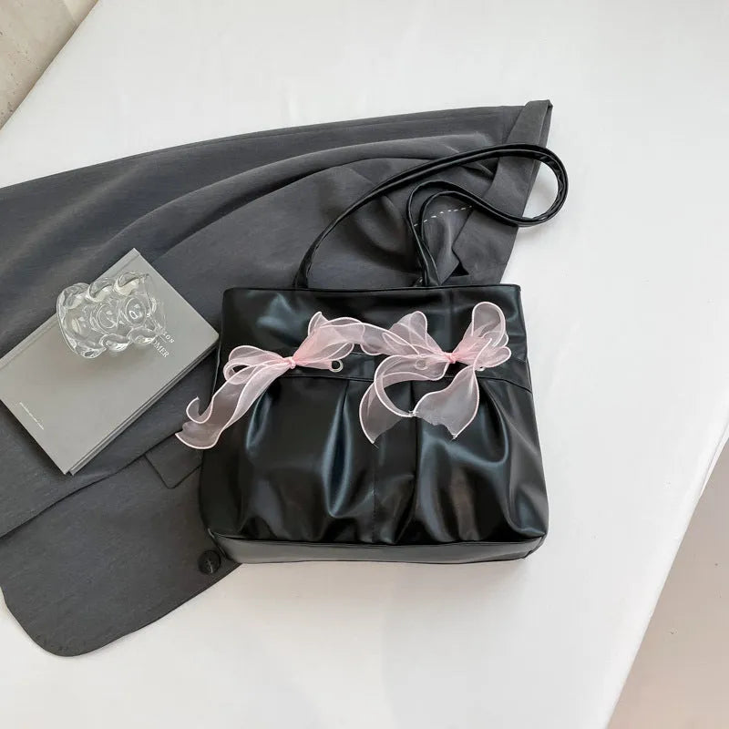 Black and pink college style bow tote bag with double straps and a front view.