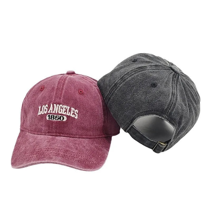 Retro washed distressed embroidered peaked cap with adjustable strap on a conical crown.