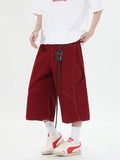 Retro denim multi-pocket workwear shorts in a wide leg cropped style, shown in red and black.